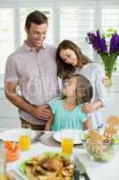Smiling family interacting with each other while having lunch together