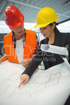 Businesswoman discussing over blueprint with a architect