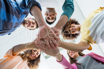 Team of smiling executives forming hand stack