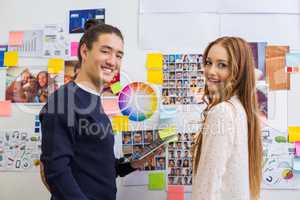 Portrait of executives standing with digital tablet in office