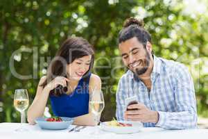 Couple using mobile phone in a restaurant