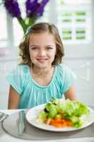 Portrait of smiling girl sitting at dining table