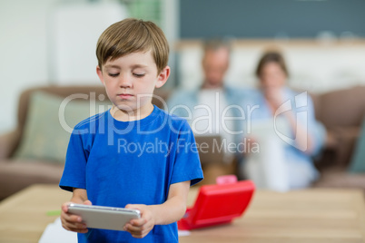 Smiling boy using digital tablet in living room