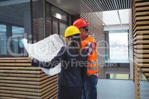 Businesswoman discussing over blueprint with a architect