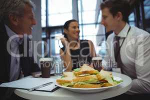 Businesspeople interacting while having breakfast