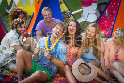 Group of friends using mobile phone at campsite