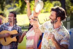 Man holding beer bottle and playing tambourine