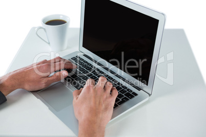 Businessman using laptop while having coffee