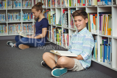 School kids reading books in library at school