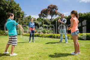 Happy family playing with the ball in park