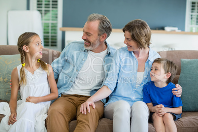 Happy family sitting together on sofa in living room