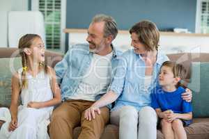 Happy family sitting together on sofa in living room