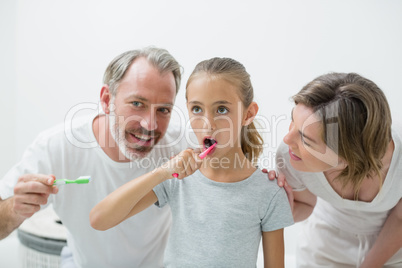 Smiling family brushing their teeth with toothbrush