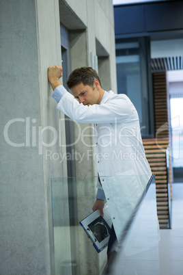 Upset male doctor standing near corridor