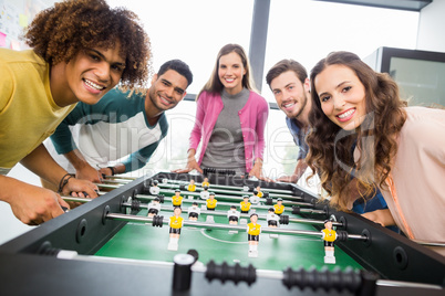 Happy executives playing table football