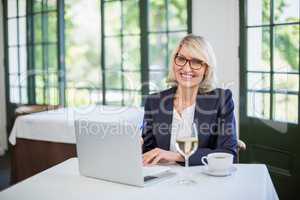 Businesswoman using laptop in a restaurant