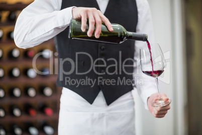 Male waiter pouring wine in wine glass