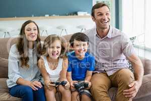 Happy family playing video games together in living room