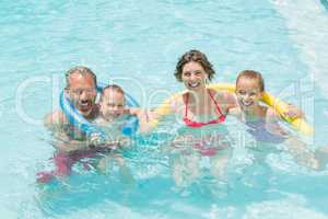 Happy parents and kids having fun in pool