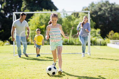 Happy family playing football in park