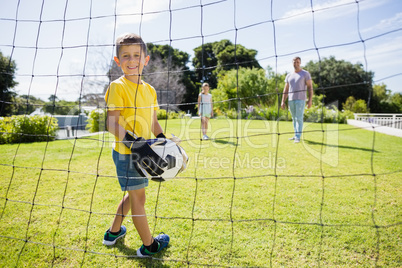 Happy family playing football in the park