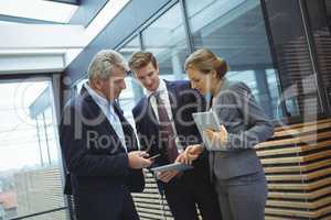 Business executives discussing over digital tablet