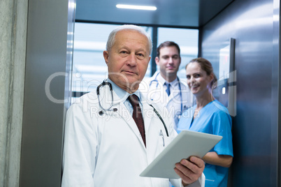 Portrait of doctors and surgeon standing in elevator