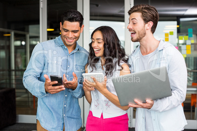 Happy executives using mobile phone, laptop and digital tablet