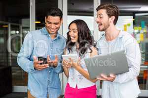 Happy executives using mobile phone, laptop and digital tablet