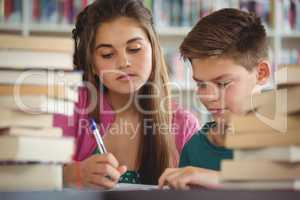 School kids doing homework in library at school