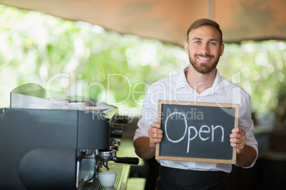 Waiter holding a board with open sign