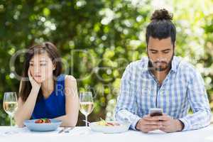 Man ignoring woman and using mobile phone