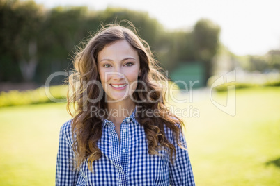 Smiling woman in checkered shirt standing in garden