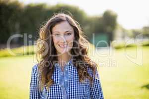 Smiling woman in checkered shirt standing in garden