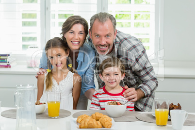 Smiling family having breakfast in the kitchen