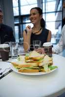 Close-up of breakfast on table with businesspeople in background