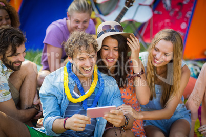 Group of friends using mobile phone at campsite