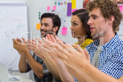 Executives applauding during presentation in conference room