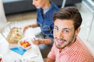 Portrait of happy male executive having breakfast