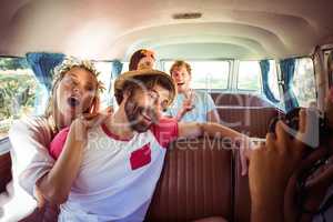 Woman taking a picture of her friends in campervan