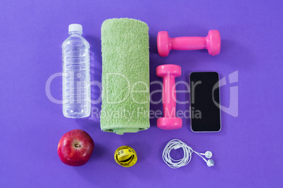 Water bottle, towel, measuring tape, dumbbells, apple, mobile phone and headphones