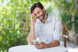 Man smiling while using his mobile phone