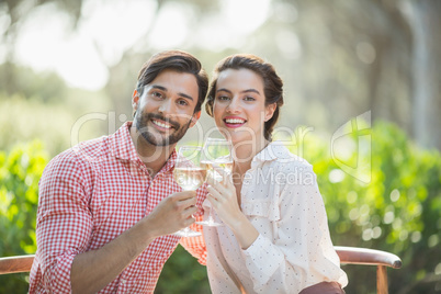 Couple toasting wine glasses while holding in restaurant