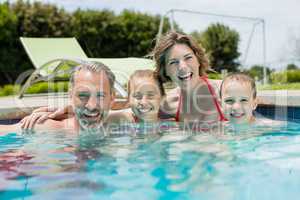 Smiling family enjoying in swimming pool