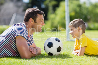 Father and son lying on grass in the park