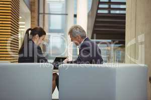 Business executives discussing over laptop