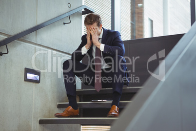 Depressed businessman sitting on stairs