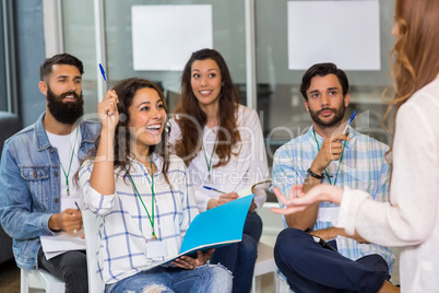 Female executive raising hand during presentation