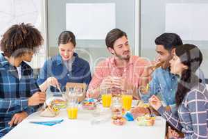 Happy executives interacting while having breakfast