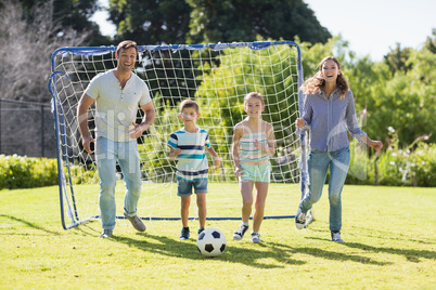 Family playing football together at the park